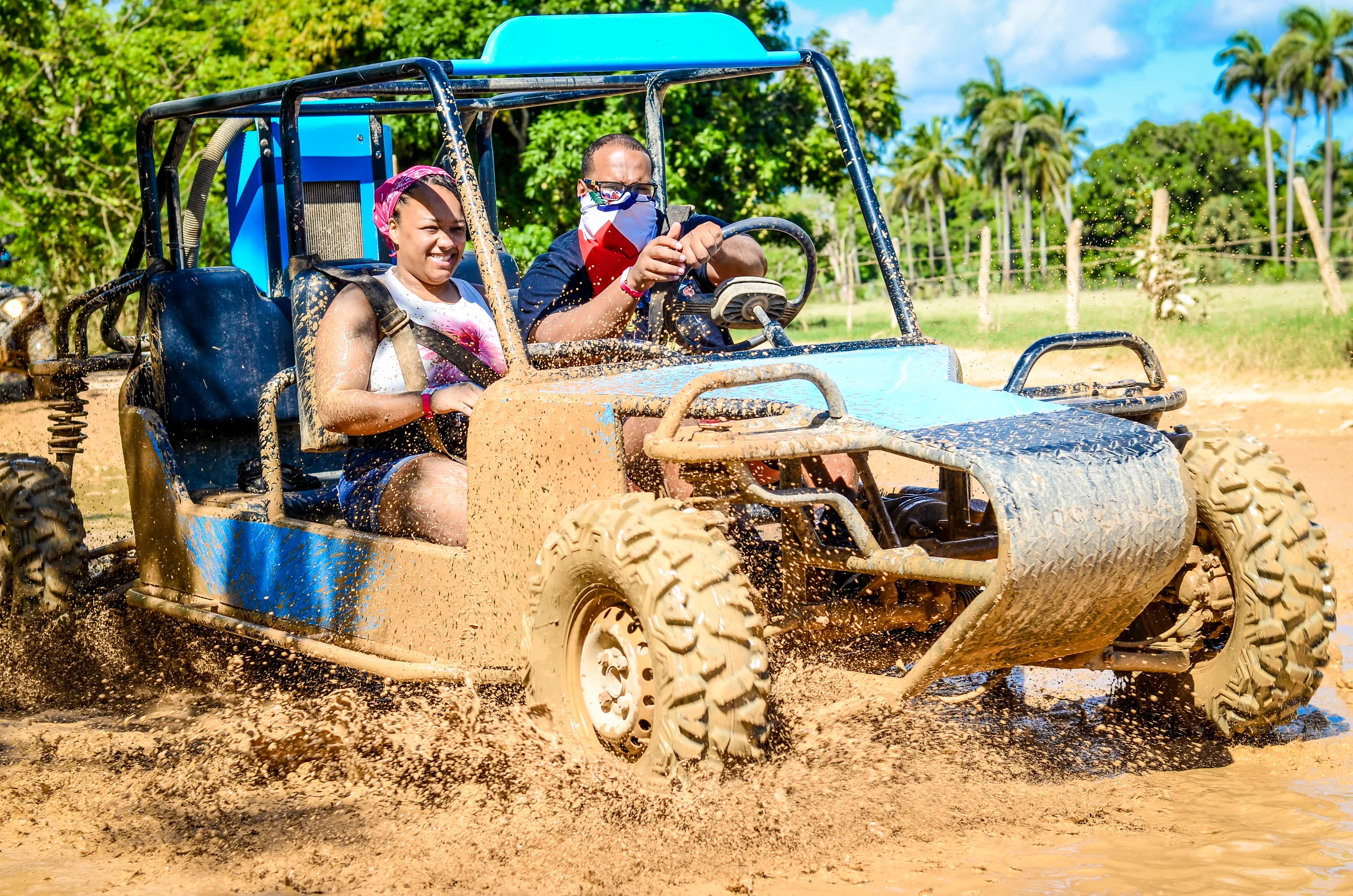 Off-road buggy kicking up dust on a red-dirt trail in Punta Cana
